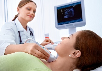 woman getting ultrasound of a thryoid from a doctor